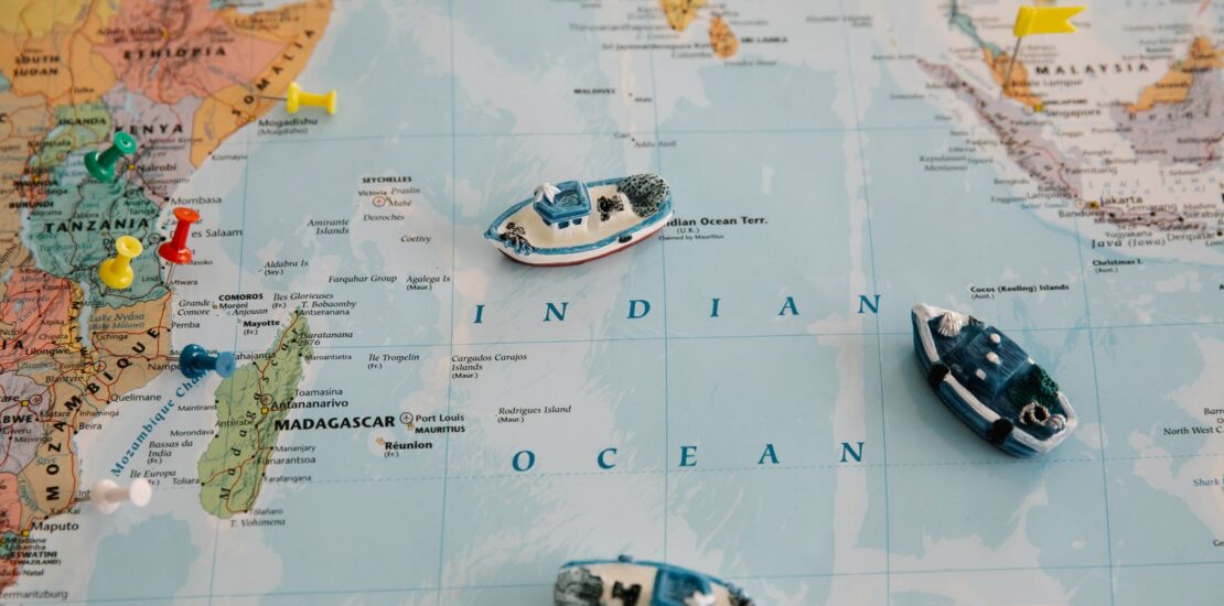 World map with toy ships and coloured pins