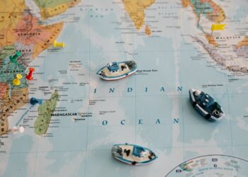 World map with toy ships and coloured pins